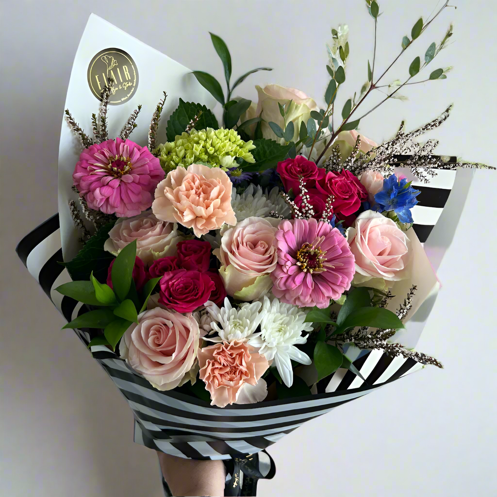 Bouquet of colorful flowers with a black and white striped wrap on a light background
