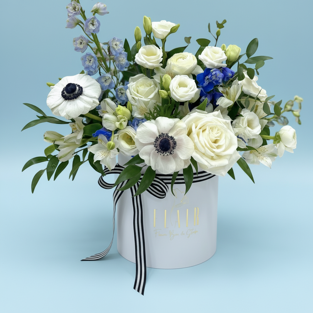 Floral arrangement in a white box with black stripes on a gray background