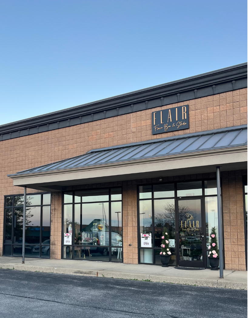 Brick building with a glass facade and Flair sign on a clear day
