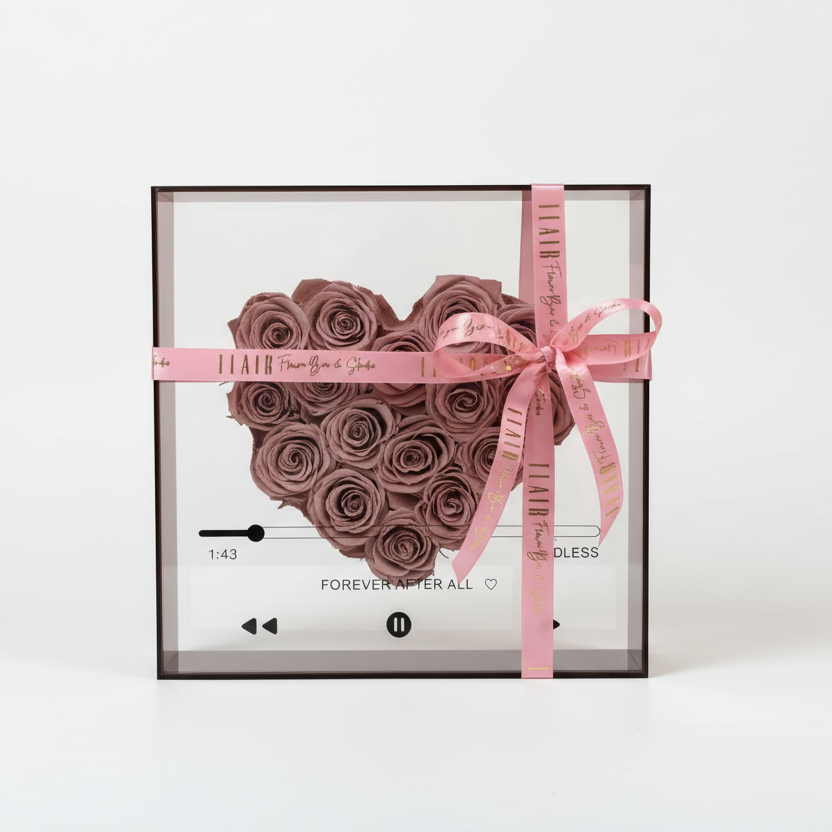 Heart-shaped rose arrangement in a clear box with a pink ribbon on a white background_Delivery to Cincinnati and Northern Kentucky by Flair Flower Bar