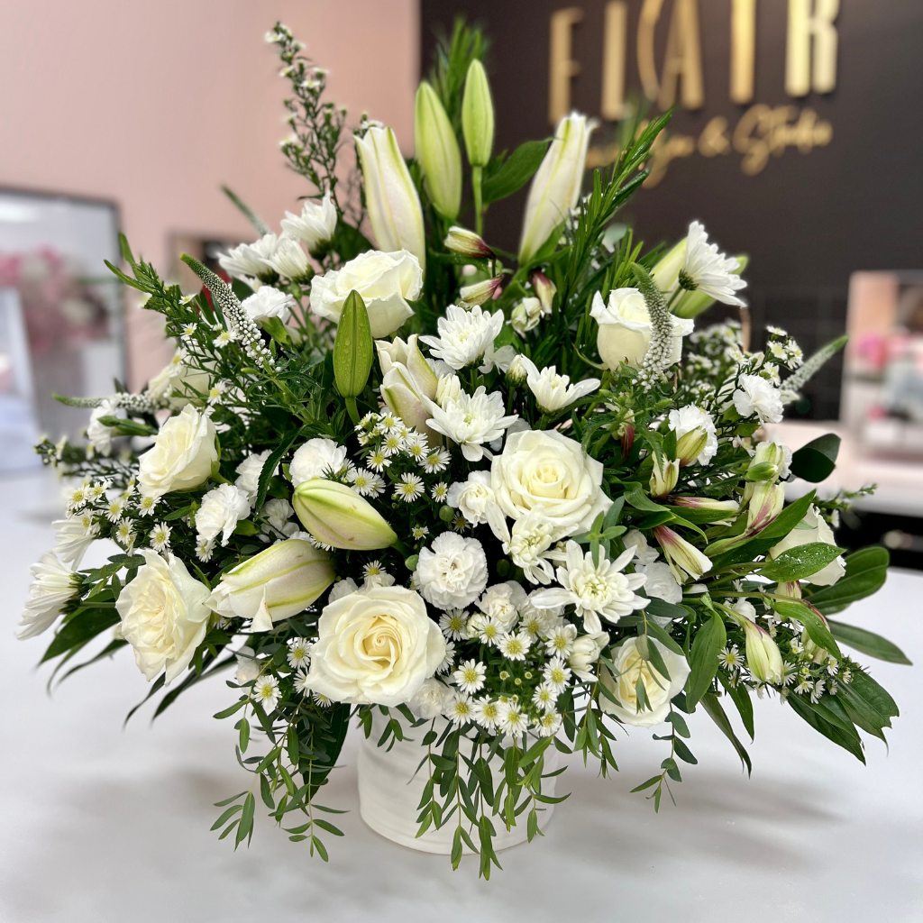 all-white sympathy flower arrangement in ceramic keepsake planter