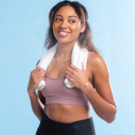 Woman in athletic wear with a towel on a light blue background