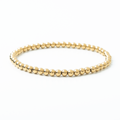 Gold beaded bracelet on a white background