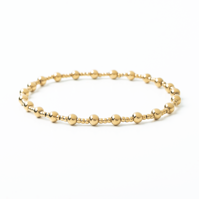 Gold beaded bracelet on a white background