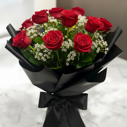 Bouquet of red roses with black wrap on a marble surface for engagement, anniversary or valentines in greater Cincinnati for delivery’