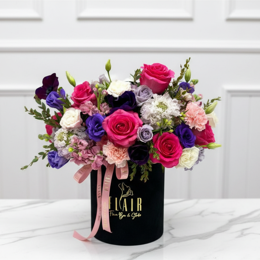 Colorful bouquet of flowers in a black container with 'Flair' branding on a white background for flower delivery in Northern Kentucky 