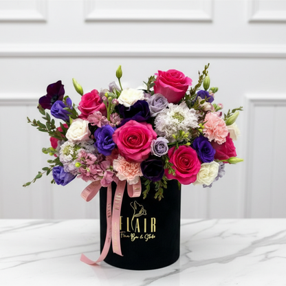 Colorful bouquet of flowers in a black container with 'Flair' branding on a white background for flower delivery in Northern Kentucky 
