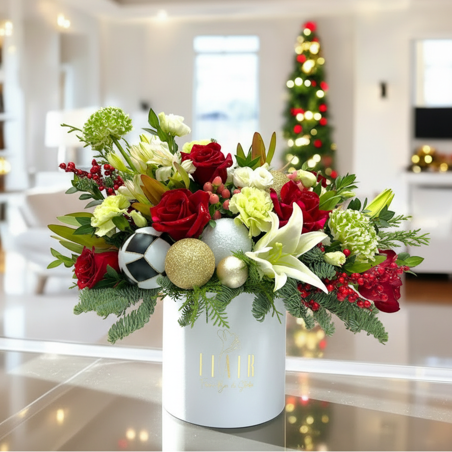 Decorative flower arrangement with Christmas ornaments in a white vase, blurred festive background.