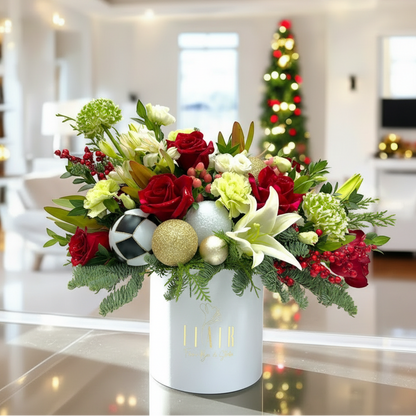 Decorative flower arrangement with Christmas ornaments in a white vase, blurred festive background.