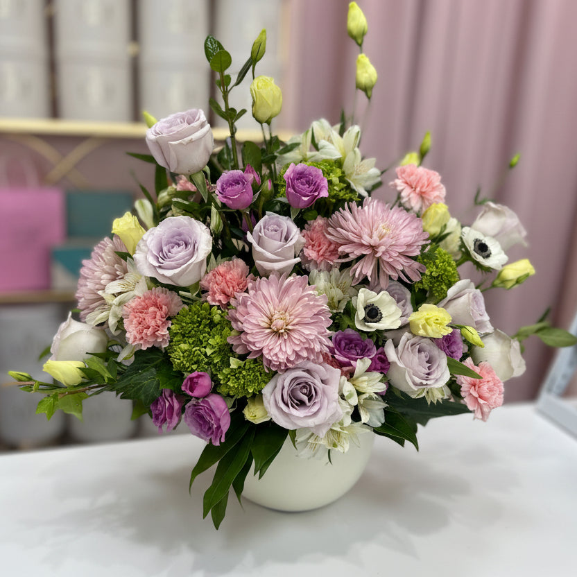 Bouquet of flowers in a white vase on a table with a blurred background