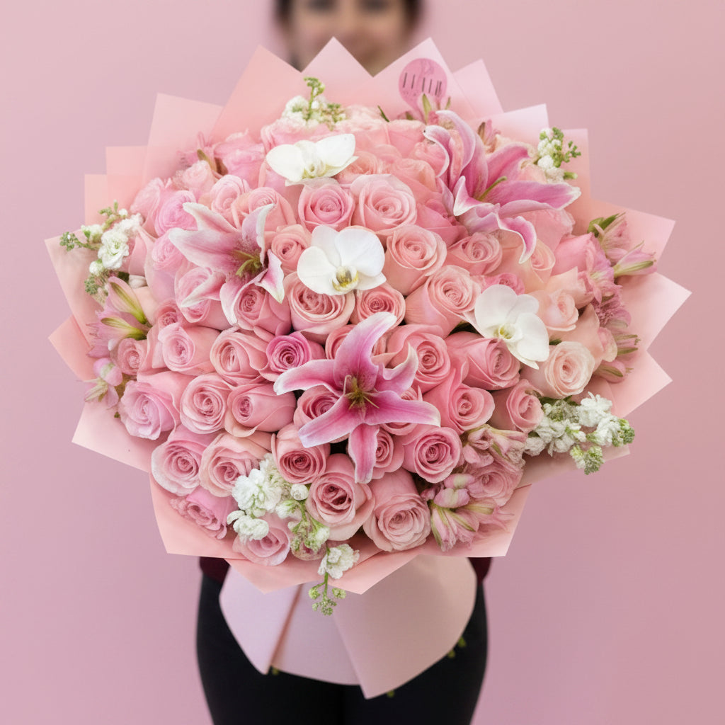 Ramo Buchon Style Rose Bouquet of pink roses with pink lily and orchid accents with a blurred background in Cincinnati