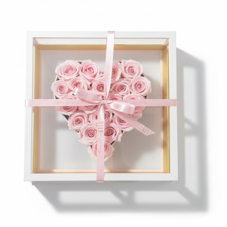 Heart-shaped arrangement of pink roses in a decorative box on a marble surface