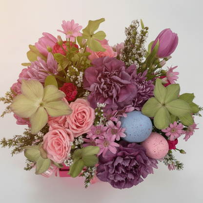 Colorful flower arrangement with pink, purple, and green flowers on a white background