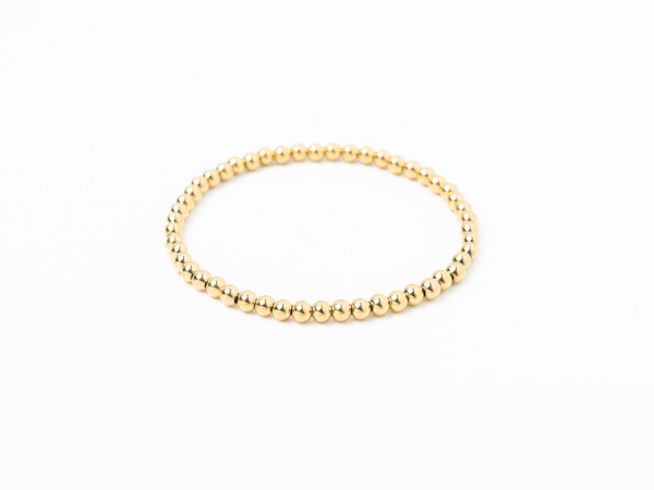 Gold beaded bracelet on a white background