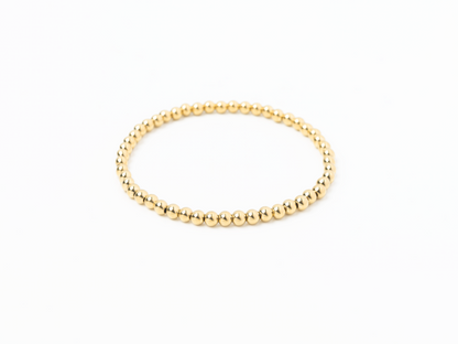 Gold beaded bracelet on a white background