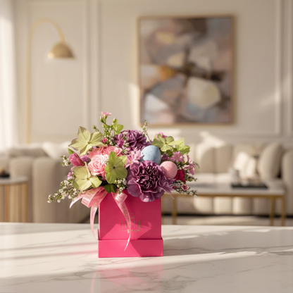 Easter floral arrangement centerpiece in a pink box on a marble surface with a blurred living room background