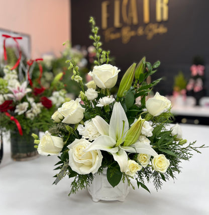 Floral arrangement in a white vase on a table with 'Flair' branding in the background.