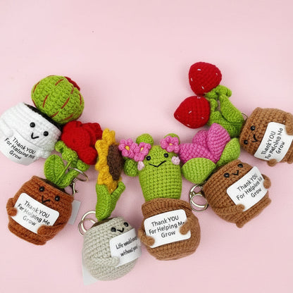 Set of crocheted cactus keychains with small signs on a white background