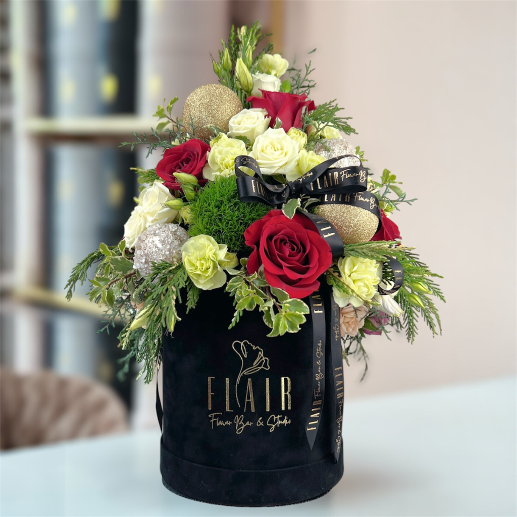Floral arrangement in a black container with 'Flair' branding on a blurred background