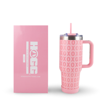 Pink tumbler with 'HOGG' logo and 'XOXO' pattern next to pink packaging box on a white background