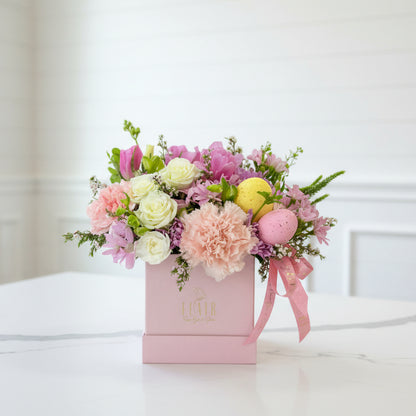 Floral Easter arrangement in a pink box with a blurred background