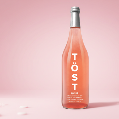 Bottle of Töst Rosé on a pink background
