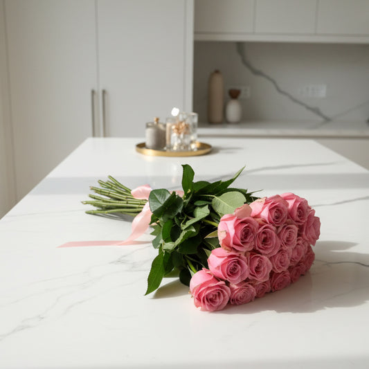 Bouquet of pink roses with green leaves on a white countertop for delivery in Cincinnati or Northern Kentucky. 