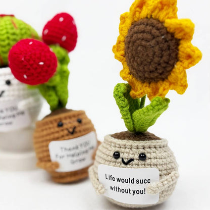 Crocheted sunflower and strawberry plant with smiling faces on a white background