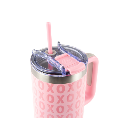 Pink tumbler with 'XOXO' pattern, handle, and straw on a white background