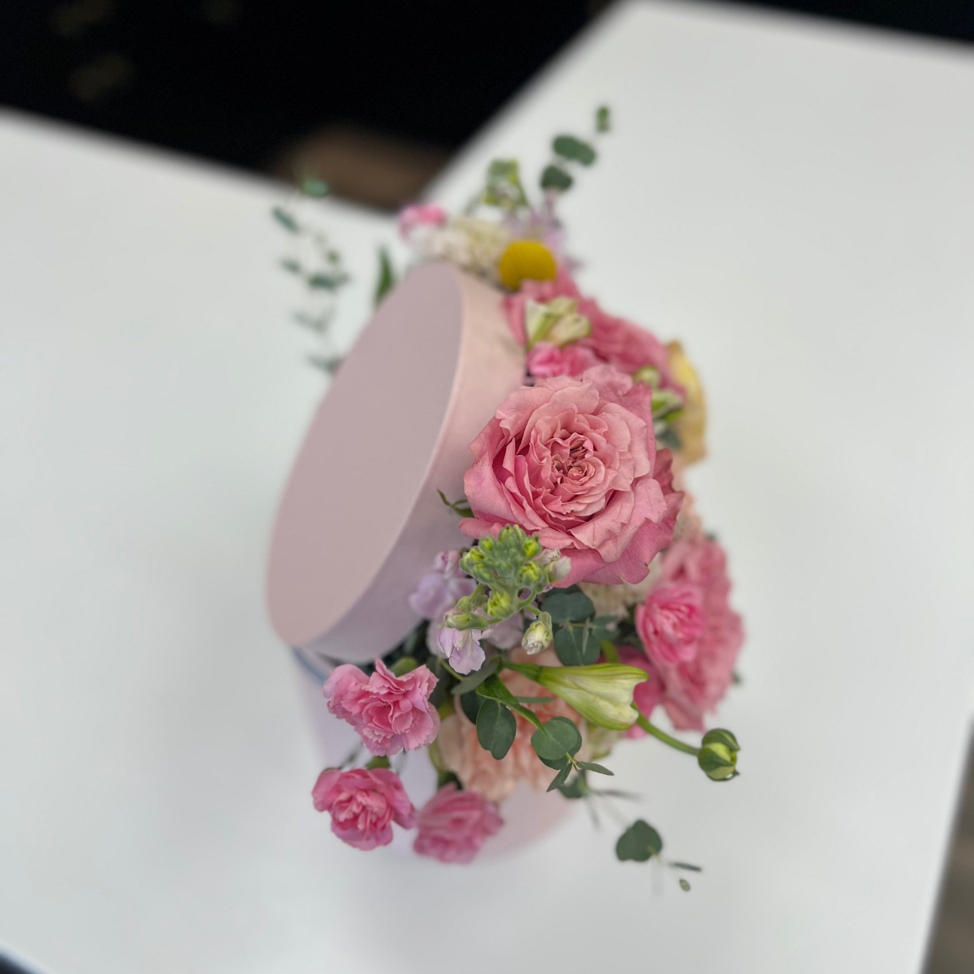 Floral arrangement on a white surface with a blurred background