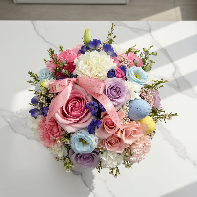 Colorful bouquet of flowers in a decorative box on a white background