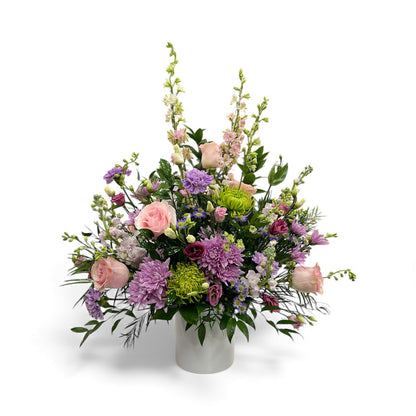 Colorful flower arrangement in a white vase on a white background