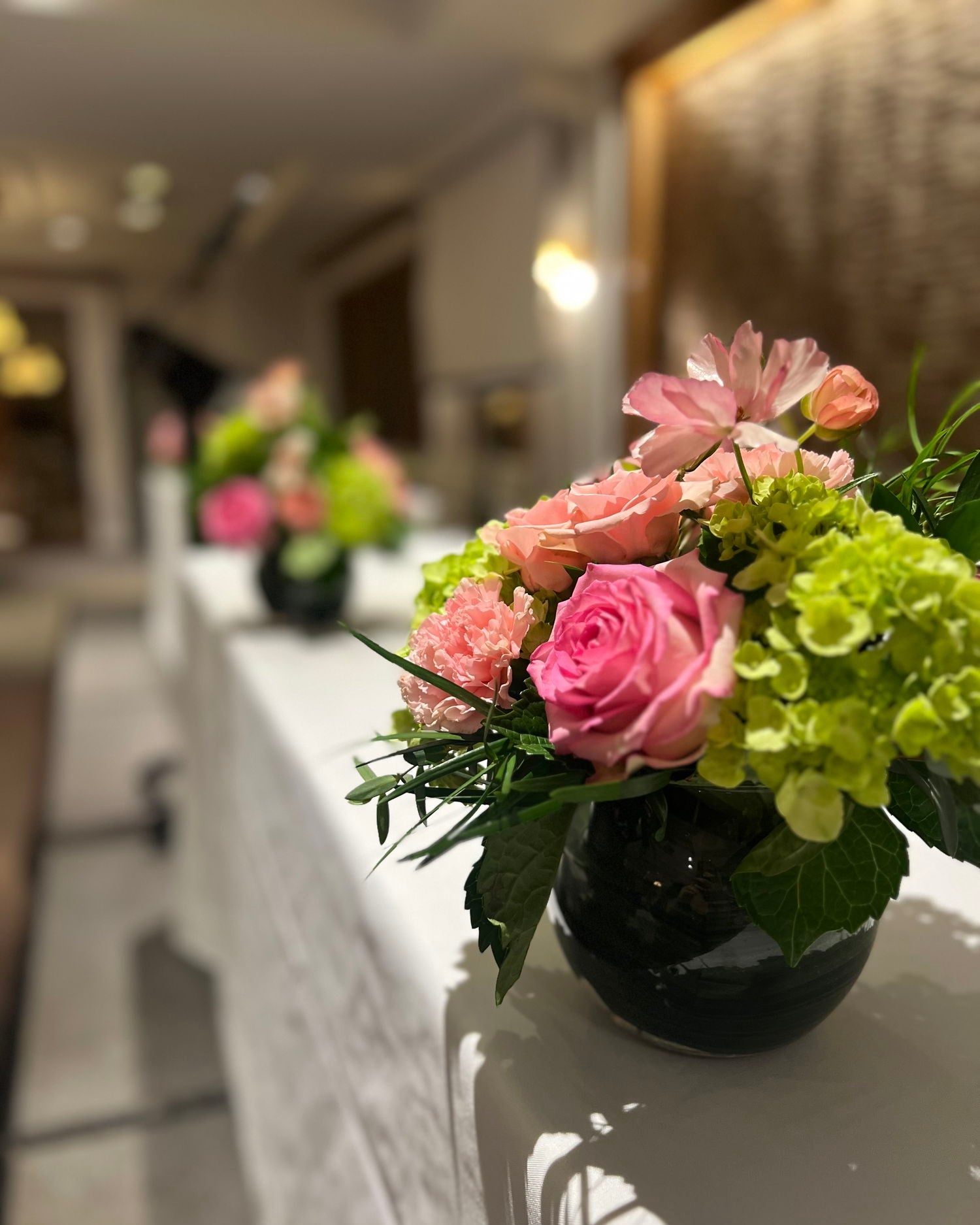 The Madison Event Center_Cincinnati AKA Ceremony_Covington, Kentucky Decorative floral arrangement on a table with a blurred indoor background