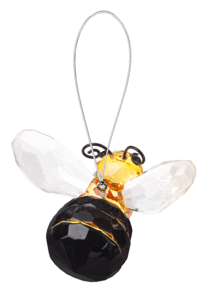 Decorative bee ornament with black body and yellow wings on a white background