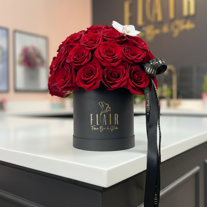 Black box with red roses on a counter in a store with 'Flair' branding.