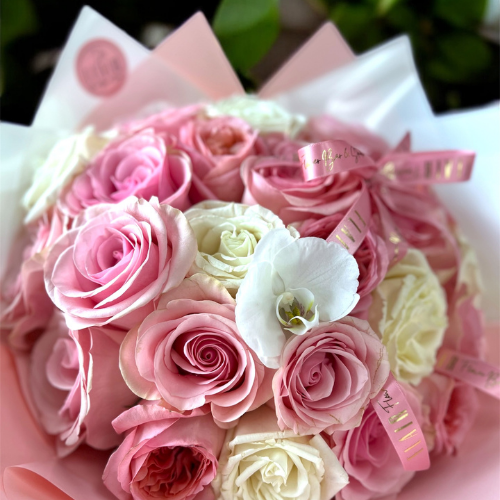 Bouquet of pink and white roses with decorative ribbons on a blurred background | Flair Flower Bar
