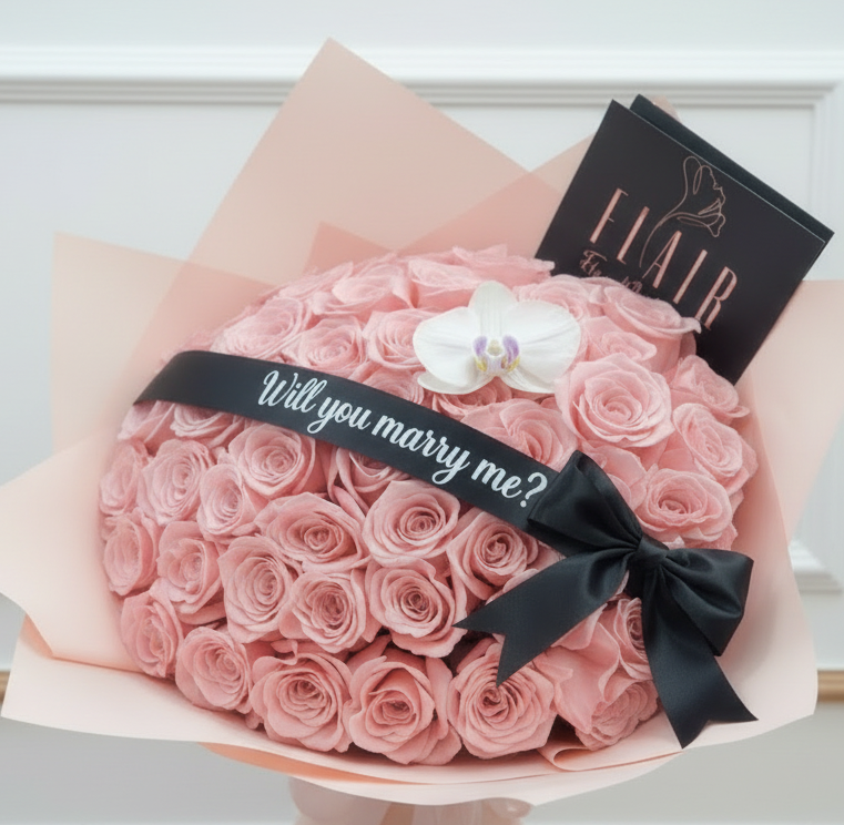 Bouquet of pink roses with a black ribbon and 'Will you marry me?' Engagement Bouquet, branded 'Flair'.