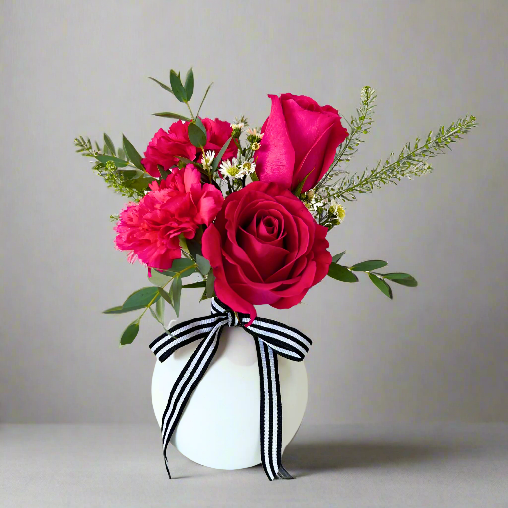 White Petite Bubble Budvase with collection of roses and carnations finished with fun black and white bow.