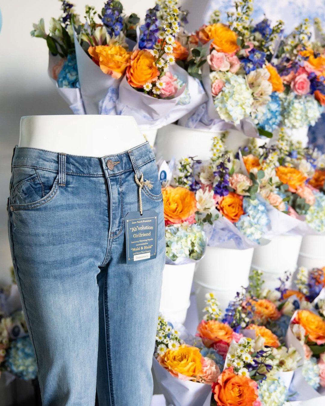 Democracy Jeans_Garage on York Event_Brand Launch_Blue jeans on a mannequin with a bouquet of flowers in the background _ Cincinnati_Northern Kentucky