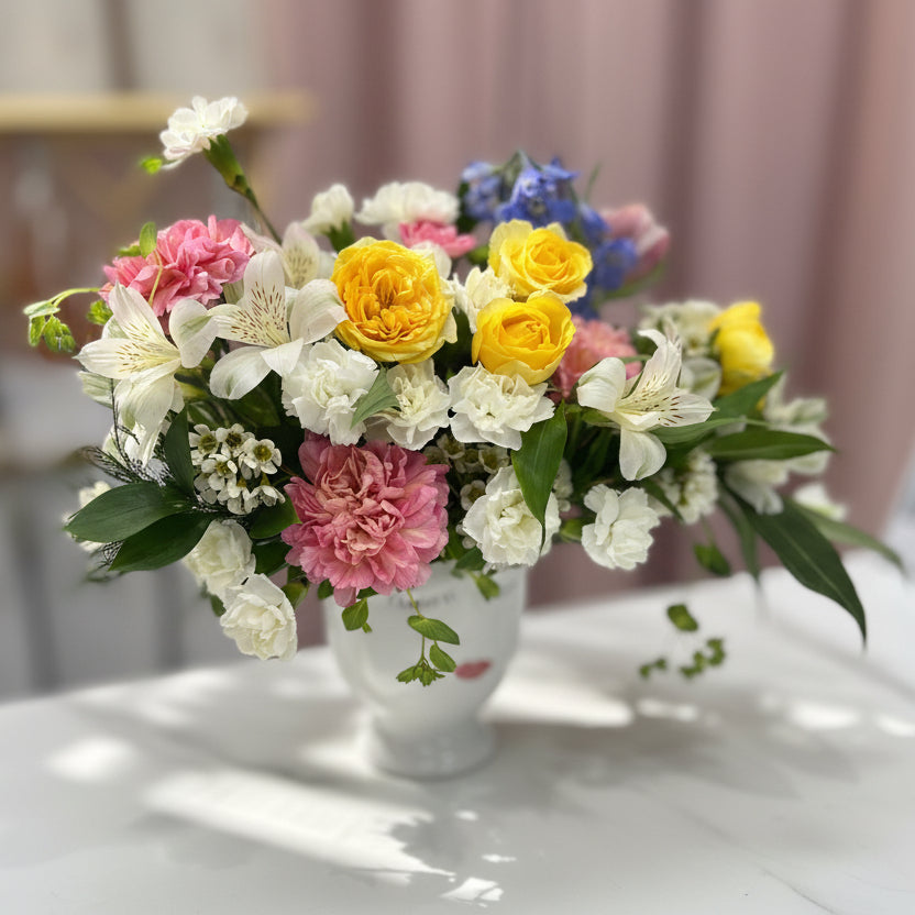 Bouquet of colorful flowers on a white surface with a blurred background