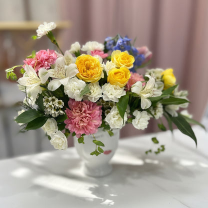Bouquet of colorful flowers on a white surface with a blurred background