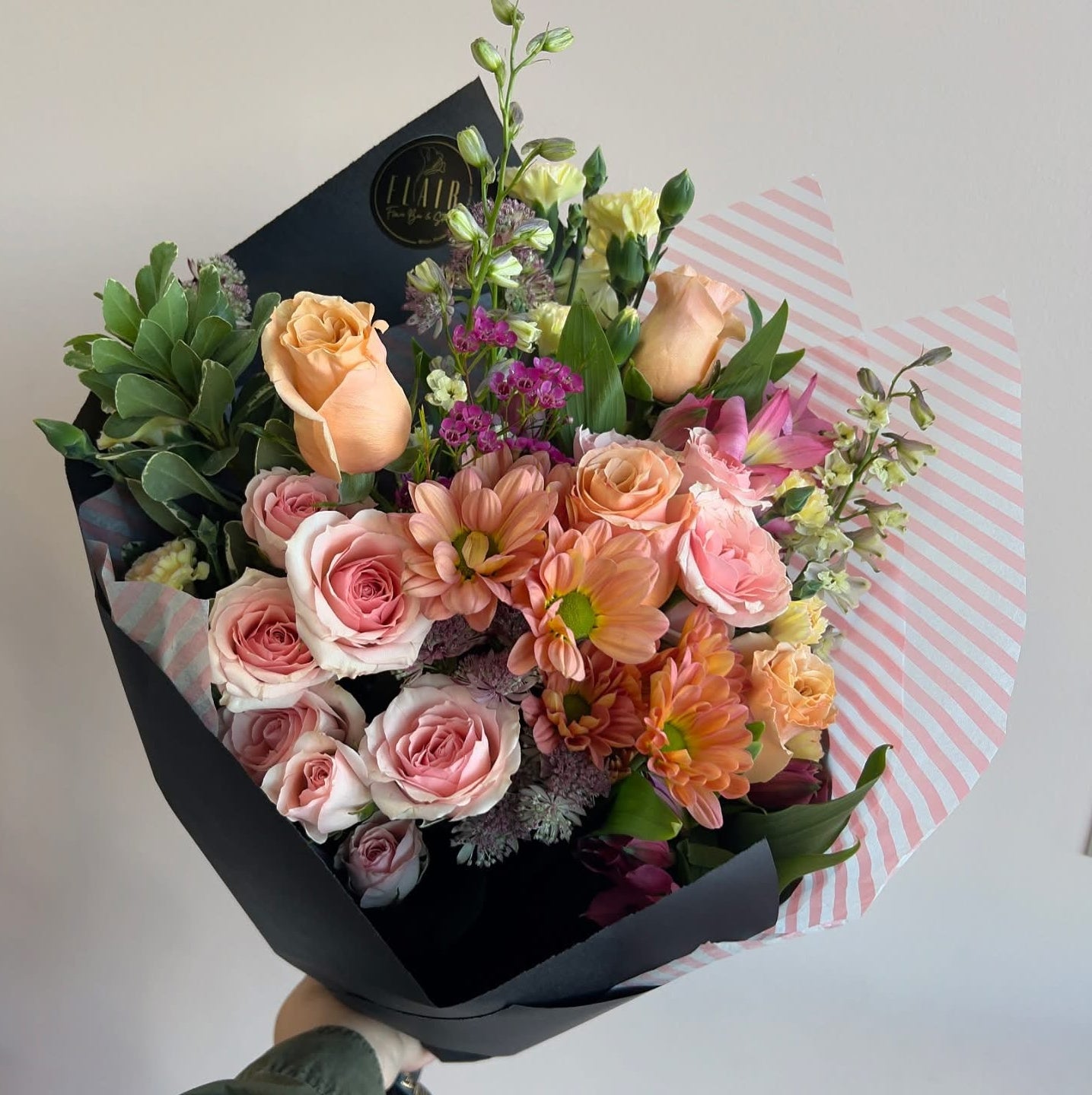 Bouquet of flowers wrapped in black paper with a white background