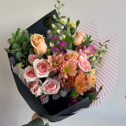 Bouquet of flowers wrapped in black paper with a white background