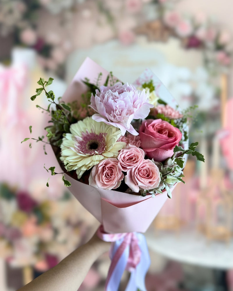 Hand-crafted bouquet with peony and roses inside Flair Flower Bar & Studio featuring signature floral wall installation in Florence Kentucky