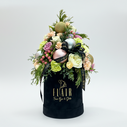 Decorative floral arrangement with ornaments on a black box labeled 'Flair' against a light gray background.