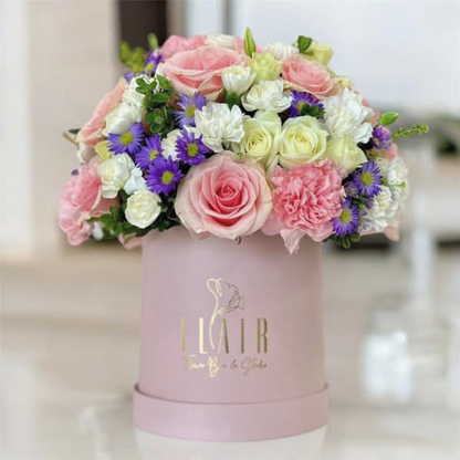 Colorful bouquet of flowers in a pink box with 'Flair' branding.