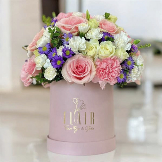 Colorful bouquet of flowers in a pink box with 'Flair' branding.