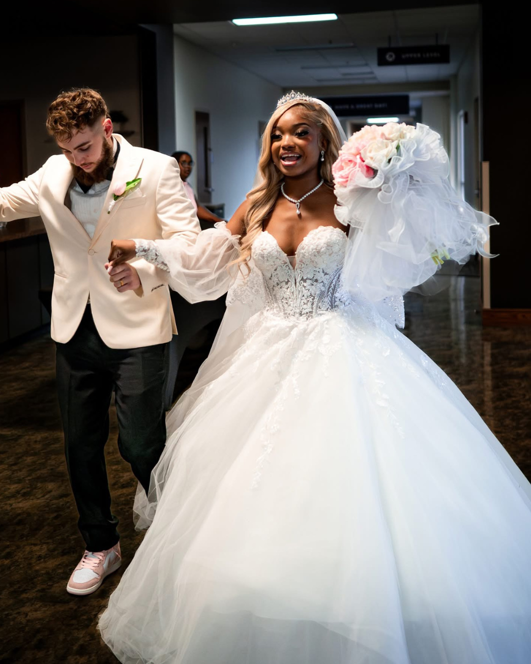 Man and woman in wedding attire walking together in a hallway. Florence, Kentucky Wedding Designer and Events