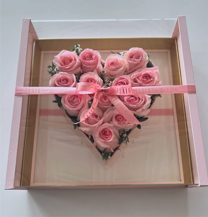 Heart-shaped arrangement of pink roses in a clear box with a pink ribbon from Flair Flower Bar in Florence, Ky