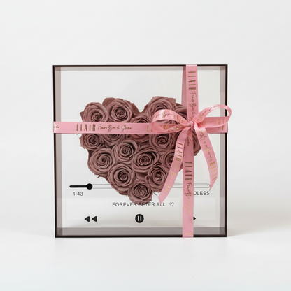 Heart-shaped rose arrangement in a clear box with a pink ribbon on a white background_Delivery to Cincinnati and Northern Kentucky by Flair Flower Bar